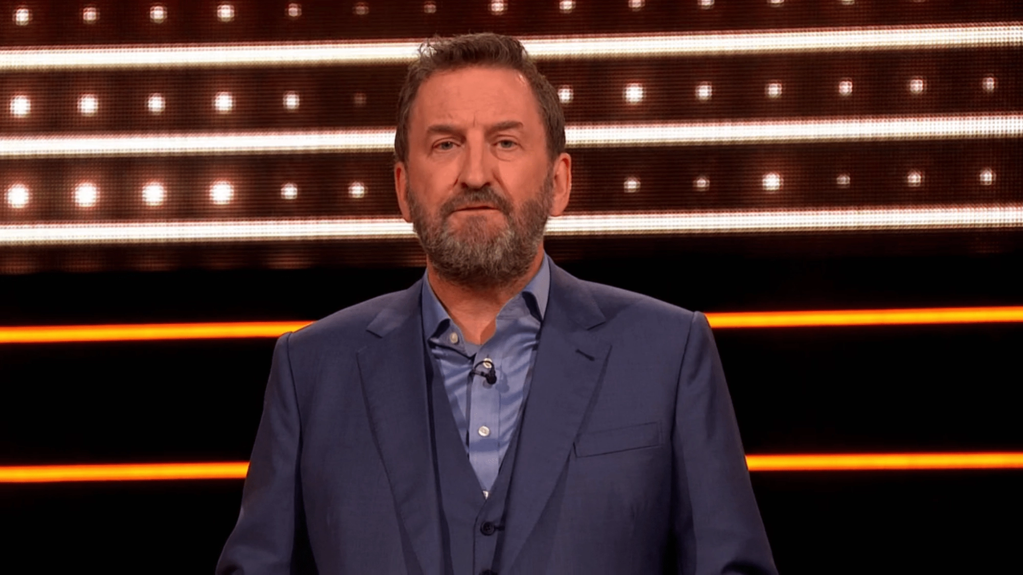 Screenshot of a man in a suit.