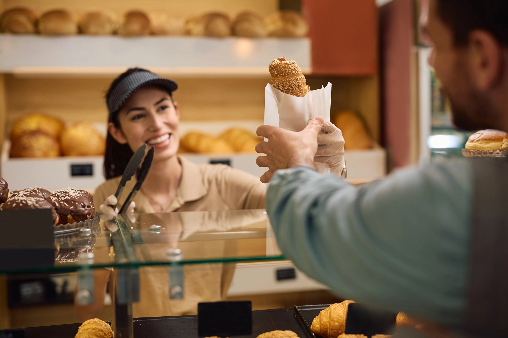 Close up worker serving a customer in a bakery.