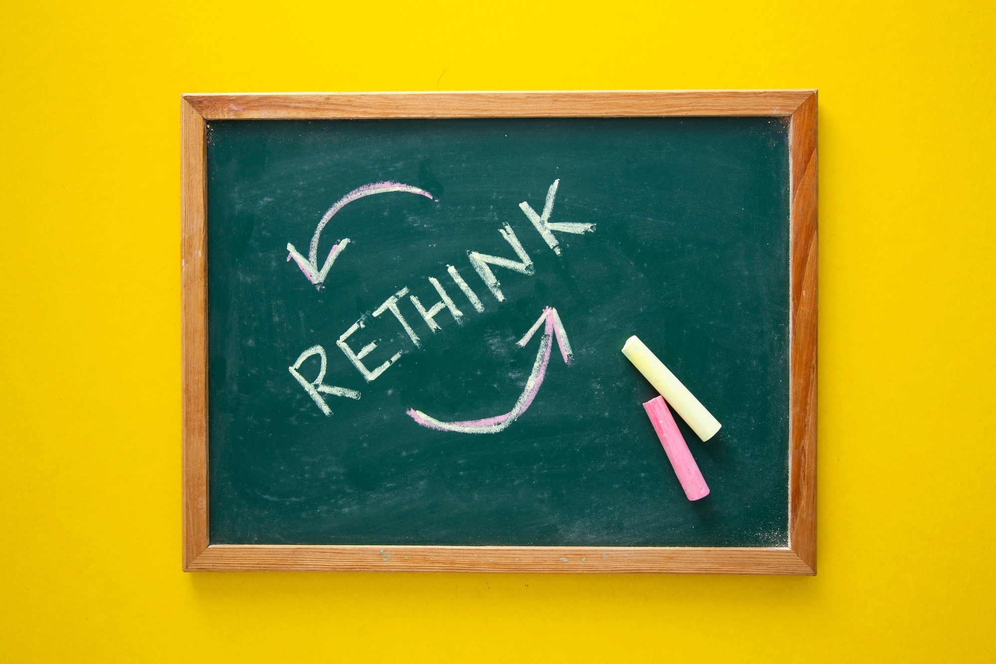 Hand writing Rethink on blackboard.
