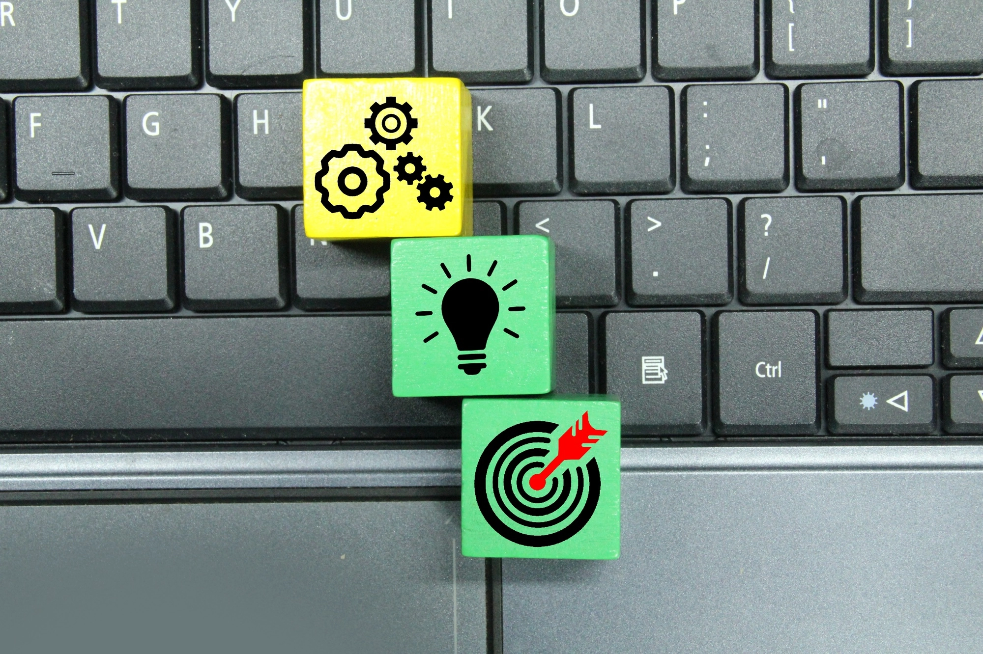 laptop keyboard, colored cubes with ideas and target management icons.