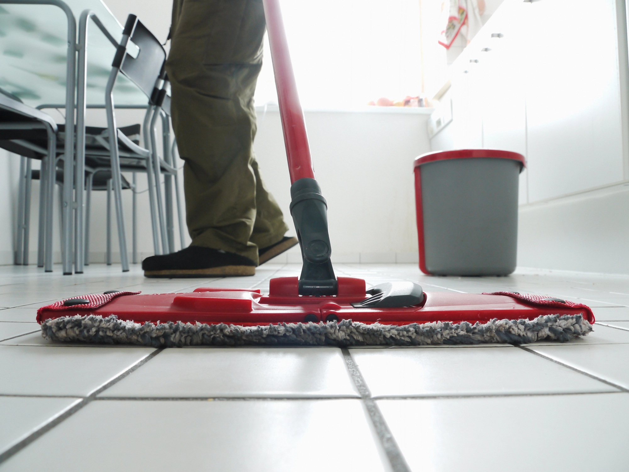 Person mopping kitchen floor.