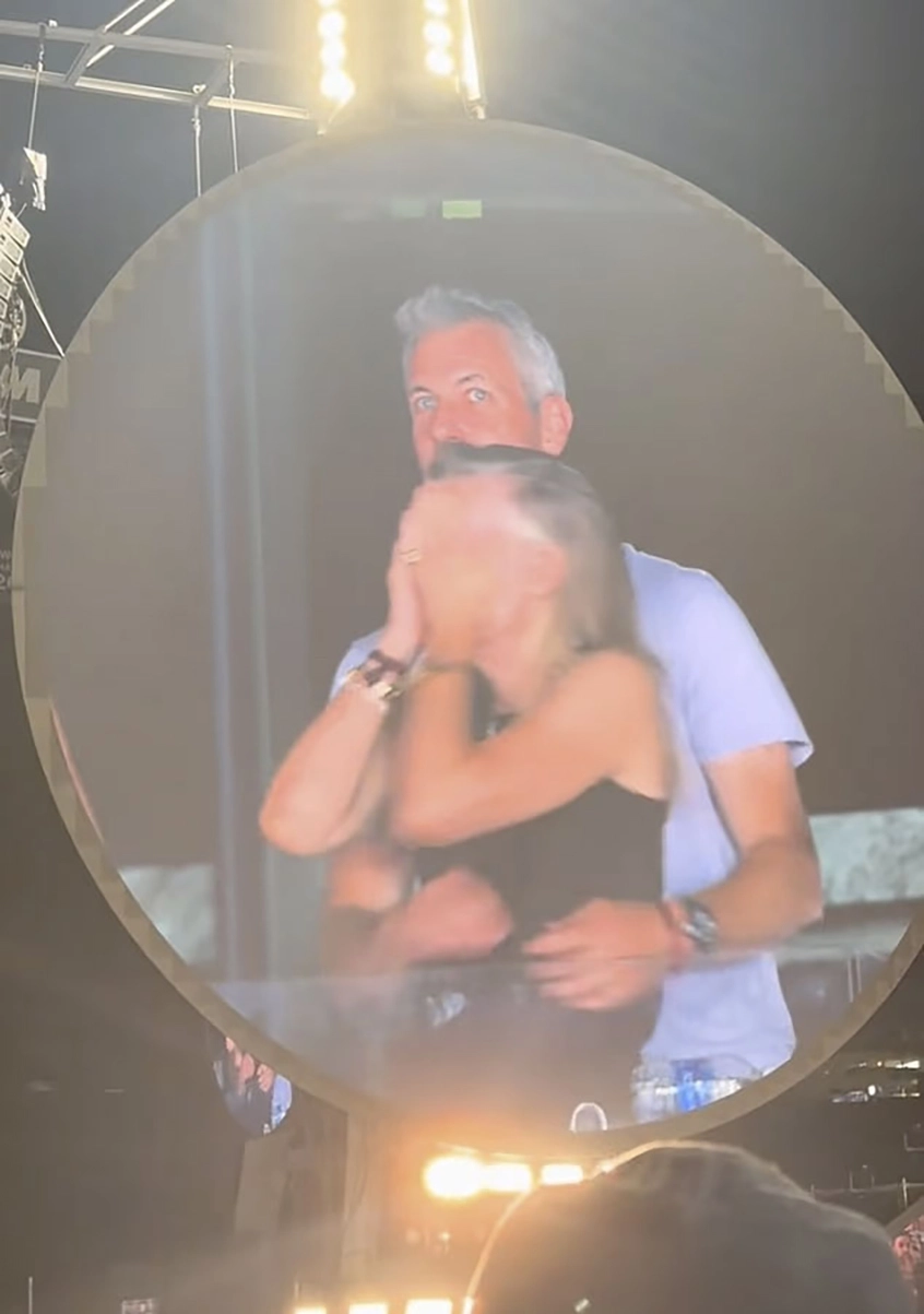 A man and woman embracing on a large screen.