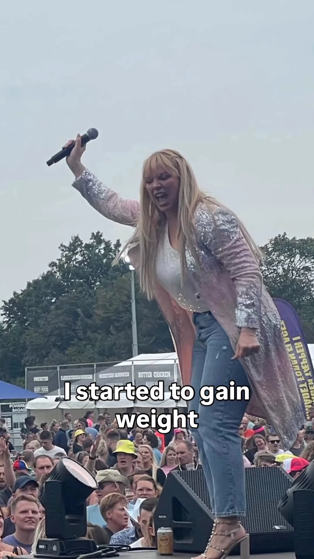 Liz McClarnon on stage, singing into a microphone, with text overlay