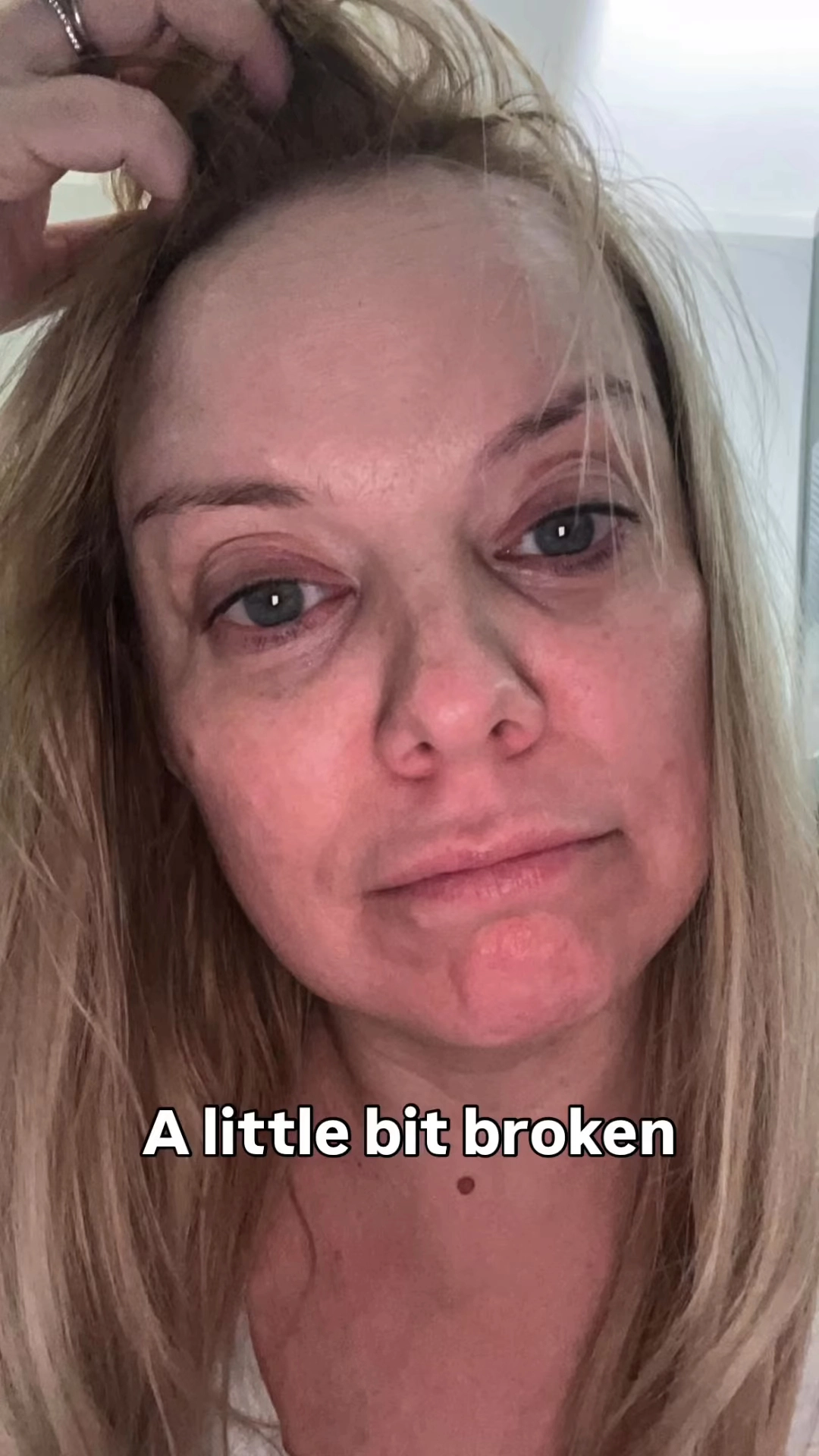 Close-up photo of a womans face, appearing tired and emotional; text overlay reads A little bit broken.