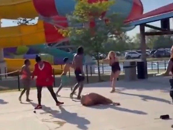 Screenshot of woman on ground as another woman tried to stop group from attacking her.
