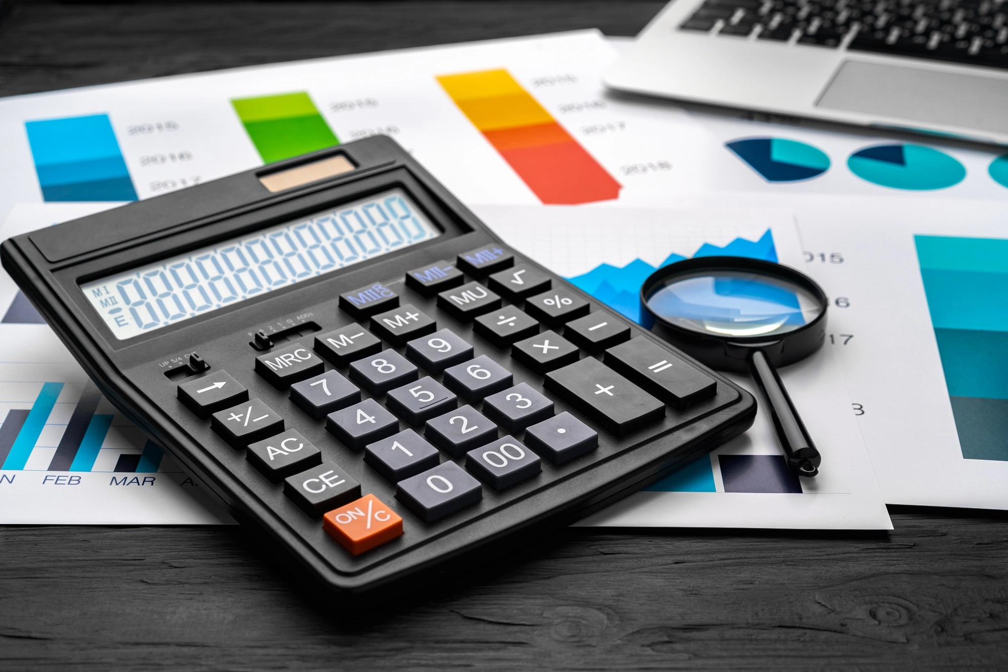 Business graphs paper and calculator on table