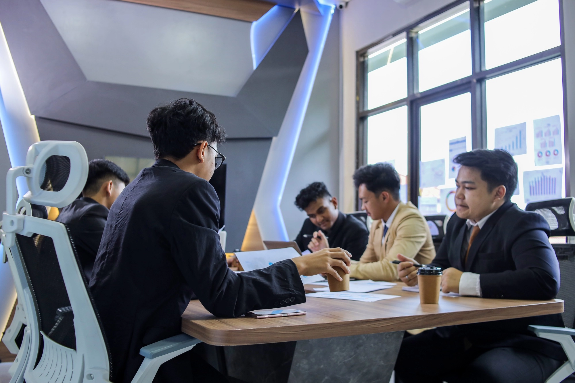Serious multiracial businesspeople gathered in boardroom discuss financial statistics, forecasting