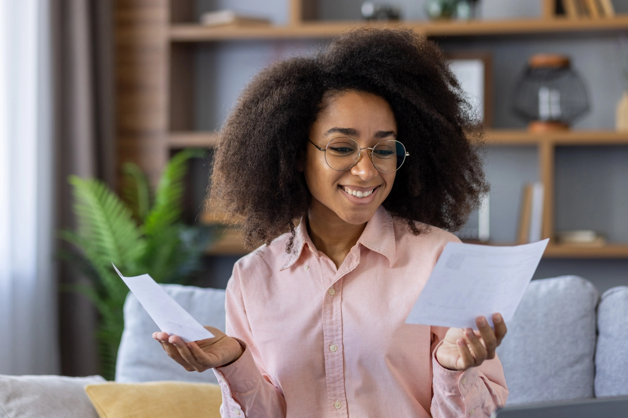 Happy woman checking documents at home, planning budget and finances