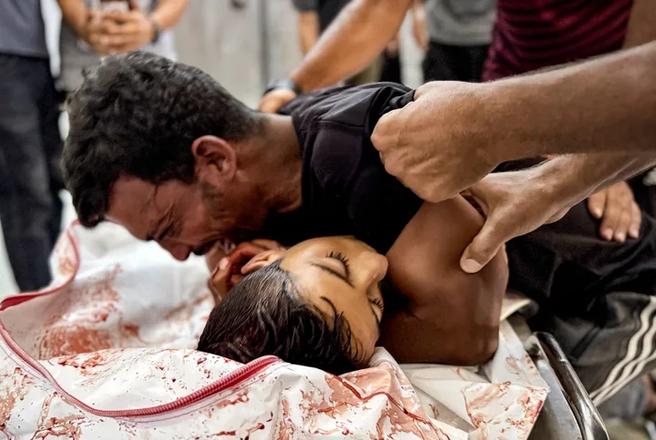 Loved ones mourn over the body of Reyyan al-Fuqaha at Nasser Hospital on Aug. 1, 2025. Israeli forces killed Reyyan and many other Palestinian aid-seekers others in an attack west of Rafah, Gaza.