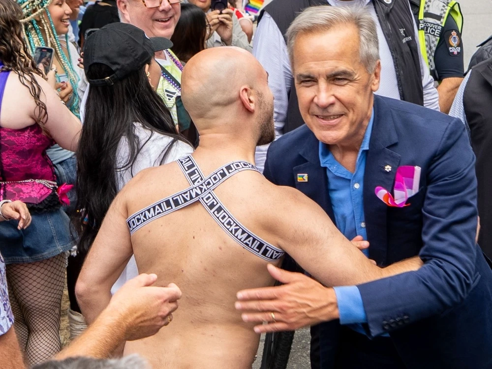 Prime Minister Mark Carney greets people while he marches in the Vancouver Pride Parade in Vancouver, Sunday, Aug. 3, 2025.