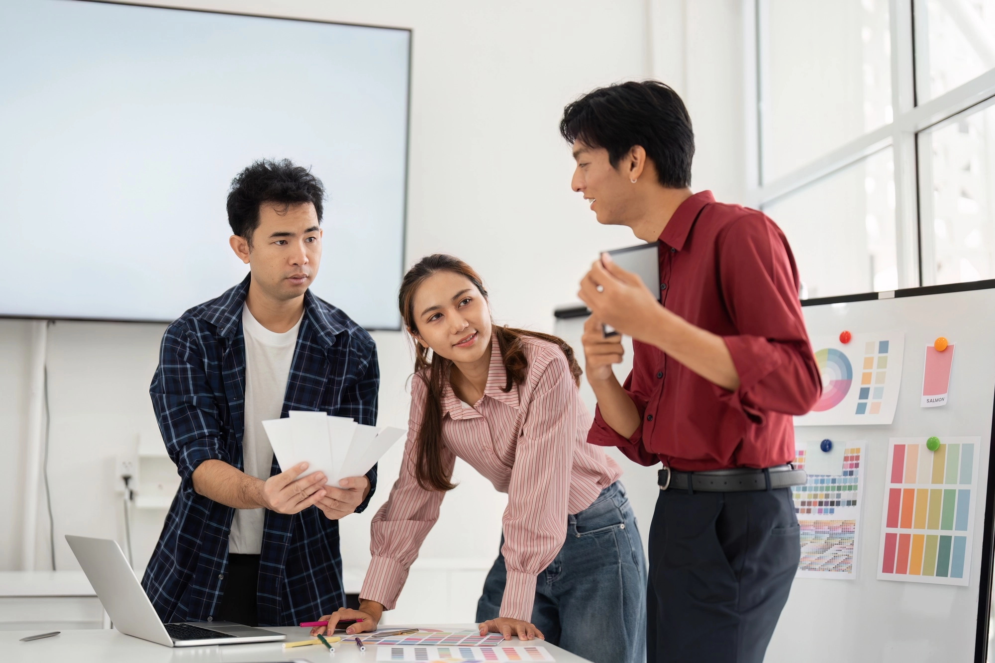 A creative team in a modern workspace reviewing design elements