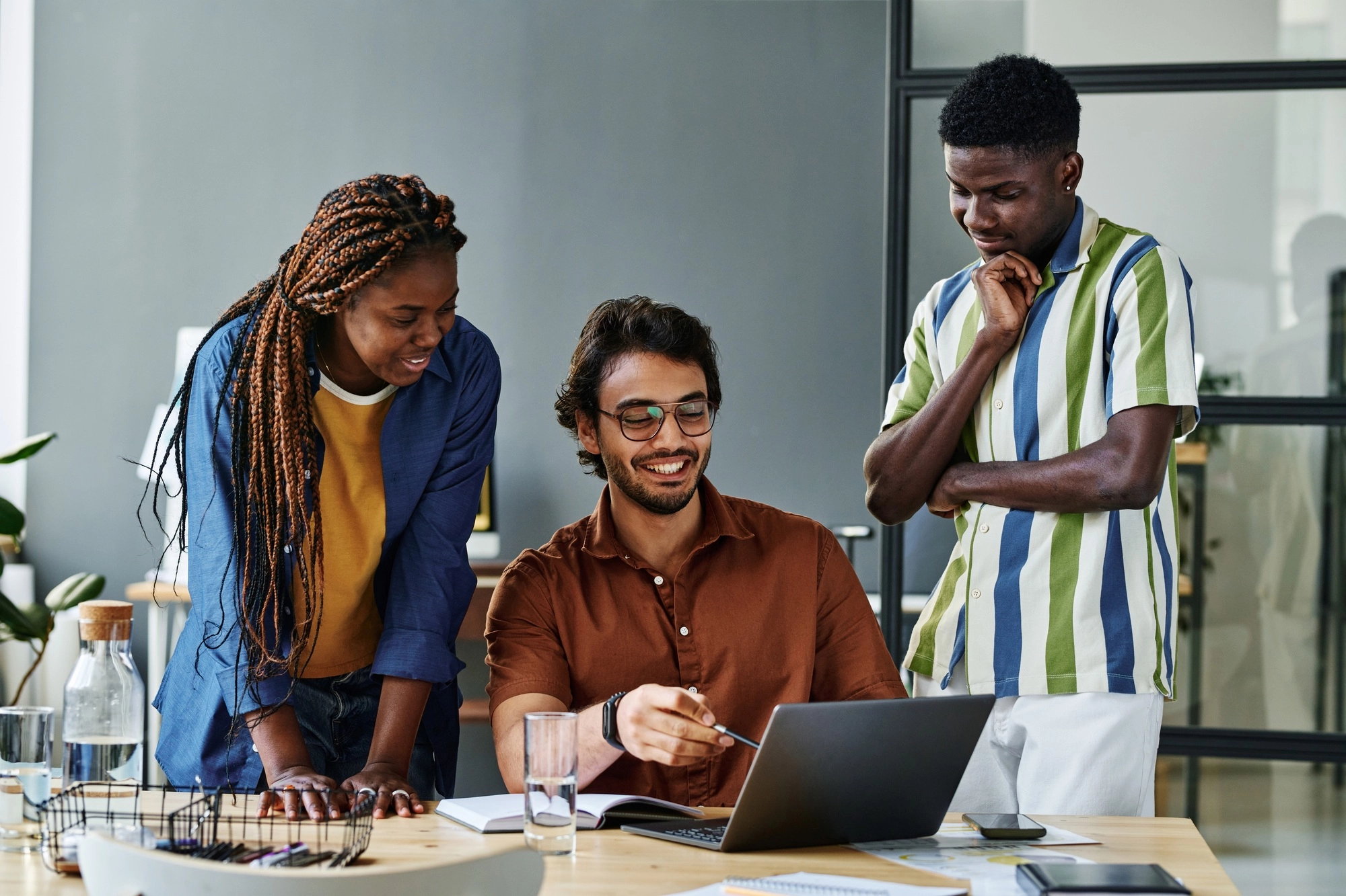 Young successful designer pointing at laptop screen during discussion
