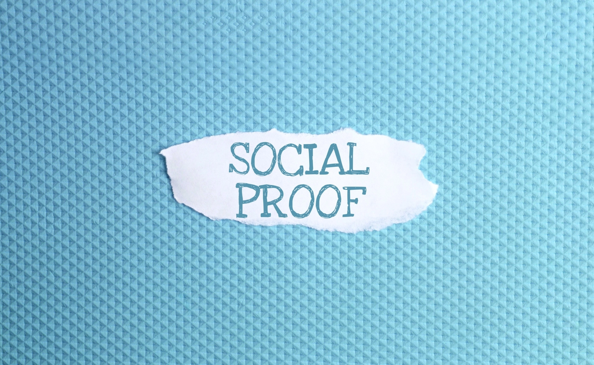a torn paper written with inscription social proof on a blue background