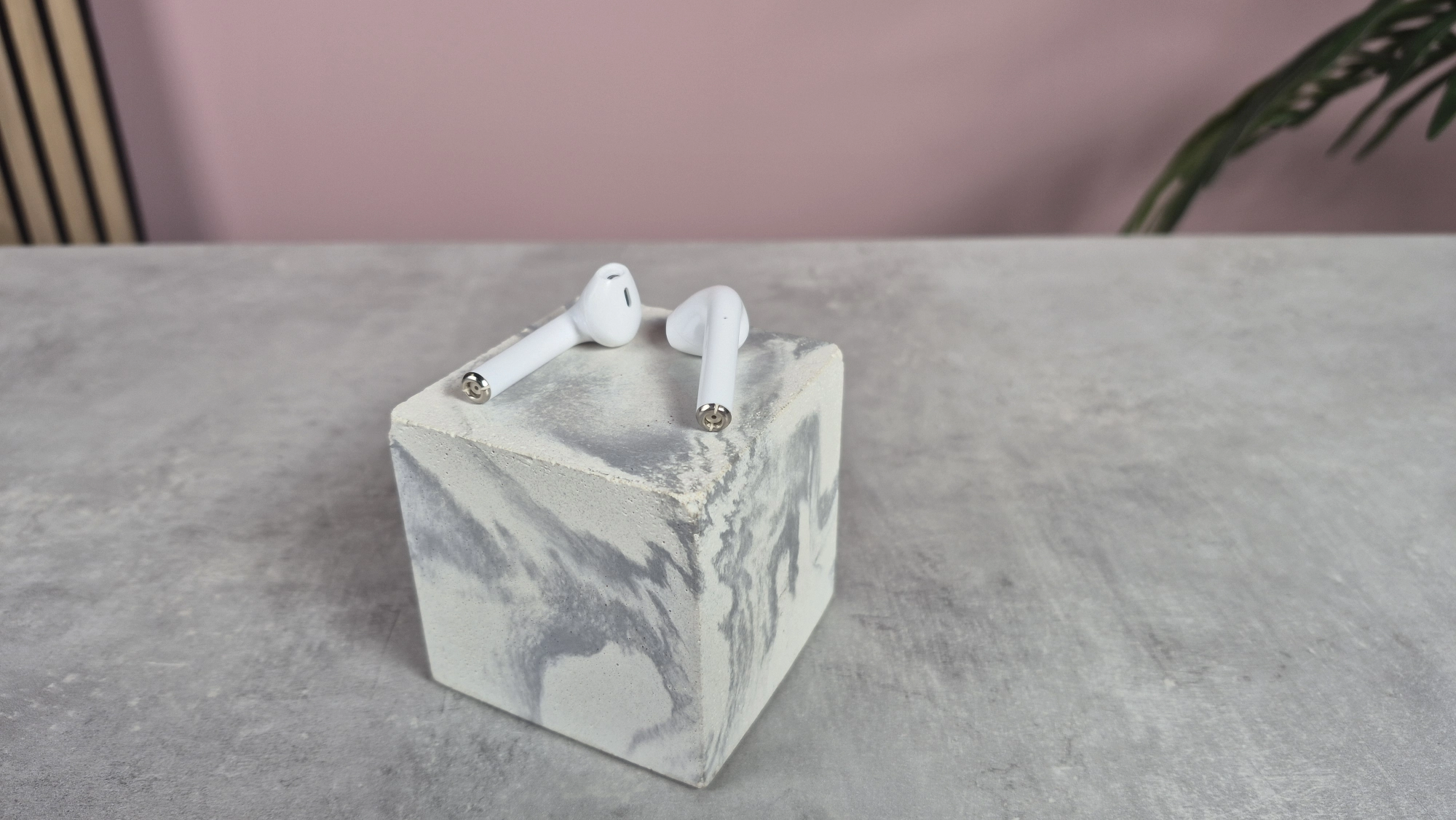 Cheap wireless earbuds balanced on top of block