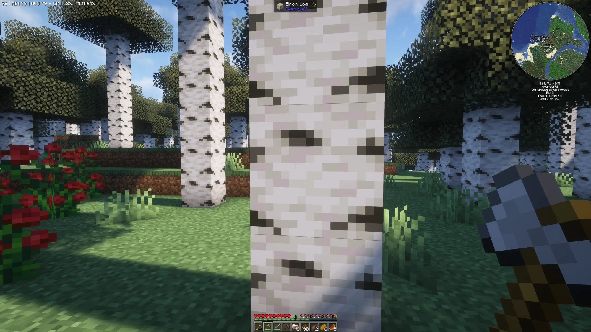 A birch tree in Minecraft with an axe in hand ready to cut it down.