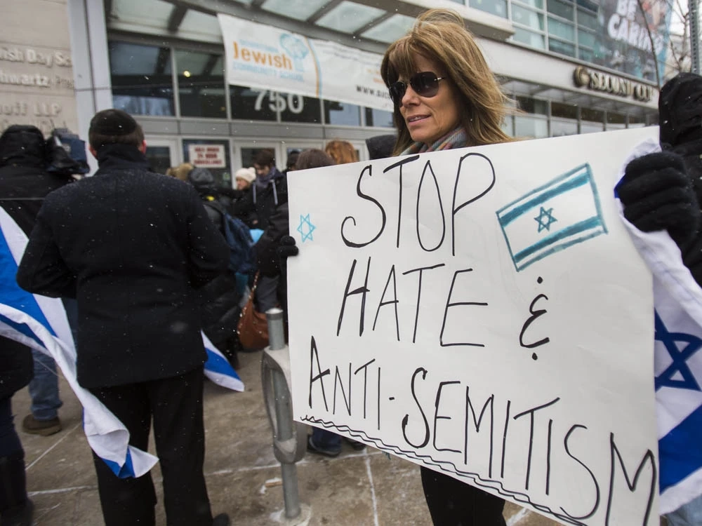 Joanne Steinberg holds a sign at a rally speaking out against anti-Semitism in Canadian society in front of the Miles Nadal Jewish Community Centre in Toronto, March 13, 2017.